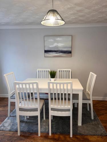 a dining room with a table and four chairs at Forge Cottage in Mountain Ash