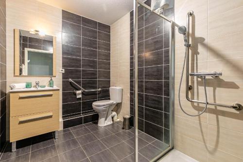 een badkamer met een douche, een toilet en een wastafel bij OVELIA Strasbourg - Les Jardins des Deux Rives in Straatsburg
