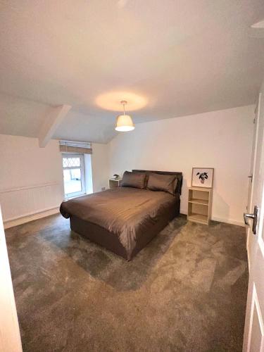 Un dormitorio con una cama grande y una ventana en Forge Cottage, en Mountain Ash