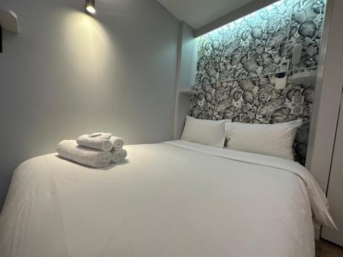 a bedroom with a white bed with towels on it at Hotel Nation Montmartre in Paris