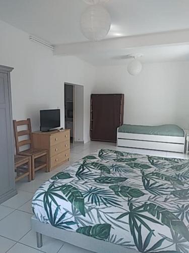 une chambre avec un lit, une chaise et une télévision dans l'établissement maison agréable avec stationnement privatif, à Angoulême