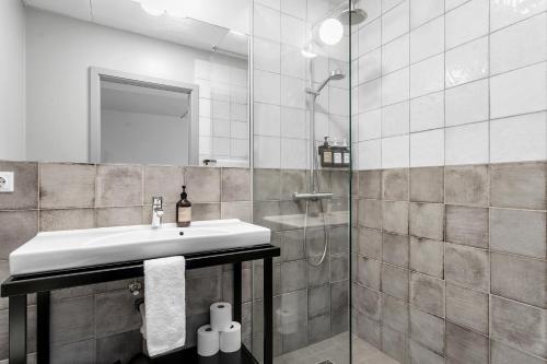 a bathroom with a sink and a shower at The Swan House by Heimaleiga in Reykjavík