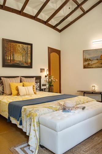 a bedroom with a king sized bed and a table at LohonoStays Villa Lani in Alibag