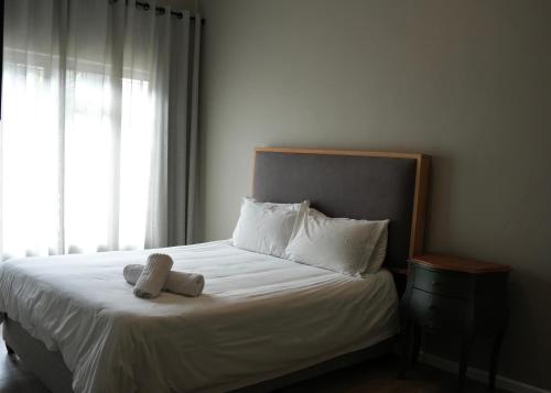 a bedroom with a bed with a teddy bear on it at iNkosi Luxury Lodge in Parow