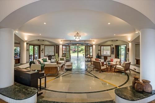 an open living room with a lot of furniture at LohonoStays Villa Lani in Alibag