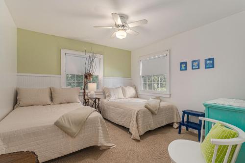 a bedroom with two beds and a ceiling fan at Painted Porch Cottage in Lakeside