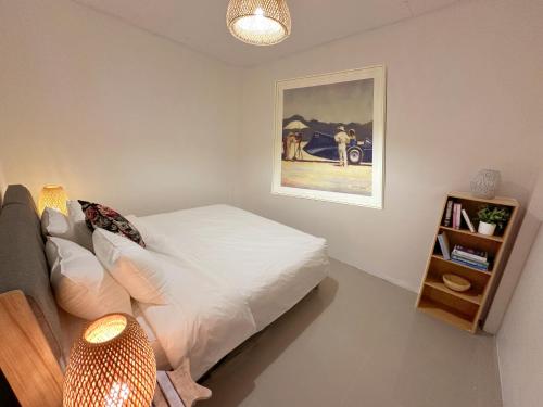 a bedroom with a bed and a painting on the wall at Bonneville Beach House in Thai Muang