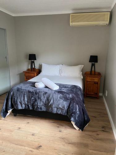 a bedroom with a bed with two towels on it at iNkosi Luxury Lodge in Parow