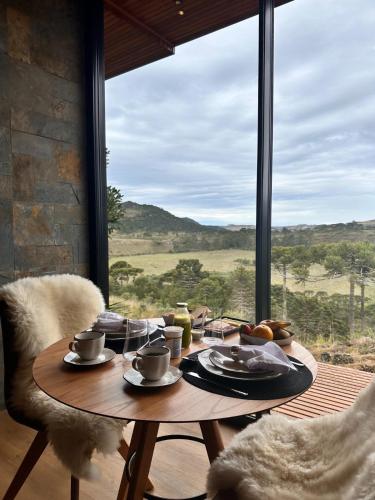 ボン・ジャルジン・ダ・セーハにあるJardim das Pedrasの窓辺に置かれたカップや皿に食べ物が載ったテーブル