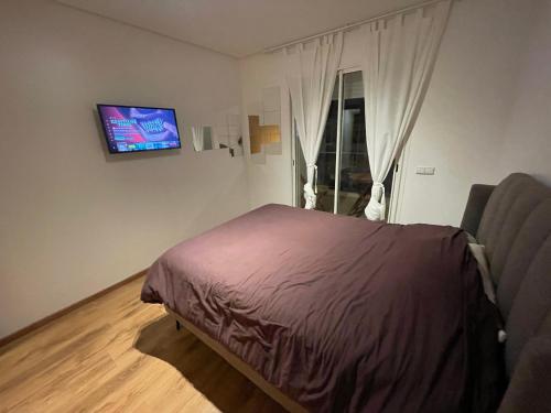 a bedroom with a bed and a tv on the wall at Terrasse En Vue in Temara