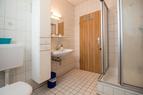 a bathroom with a shower and a sink and a toilet at Apartment Haus Julia in Norderney