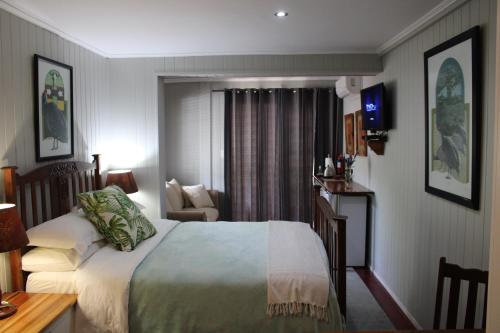 a bedroom with a bed and a desk and a chair at 14 Mount Joy in Knysna