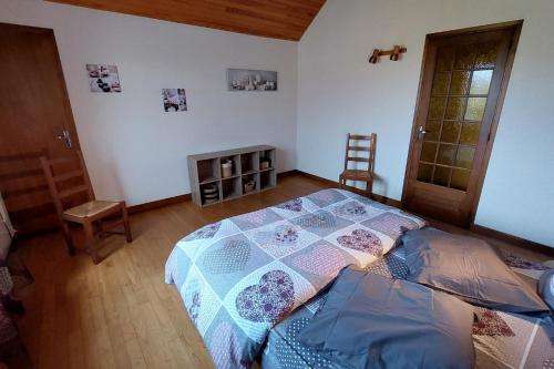 1 dormitorio con 1 cama con edredón en La Maison des 3 Bouleaux 