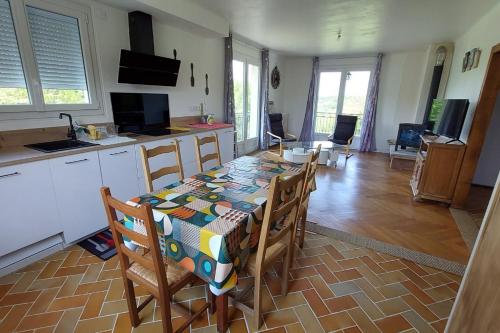 une cuisine et une salle à manger avec une table et des chaises dans l'établissement La Maison des 3 Bouleaux, à Lafeuillade-en-Vézie