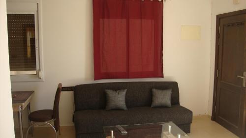 sala de estar con sofá y cortina roja en Appartement en Oujda