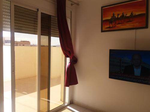 Habitación con ventana y una foto en la pared. en Appartement en Oujda