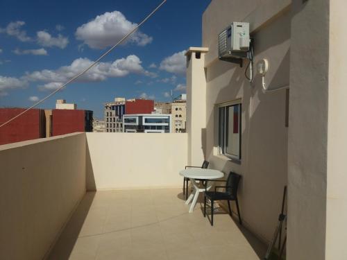 un balcón con una mesa en el lateral de un edificio en Appartement en Oujda