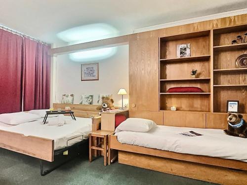- 2 lits dans une chambre avec rideau rouge dans l'établissement Studio skis aux pieds pour 4, proche commerces et balcon sud à Tignes - FR-1-411-440, à Tignes