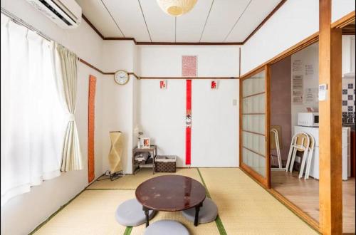 a living room with a table and a window at 新宿から快速15分の三鷹駅徒歩3分 最大5名 ゆったり和室【MITAKA NAGOMI ROOM】　 in Musashino