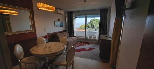 a living room with a dining room table and chairs at Appart'hôtel Le Trianon in Arcachon