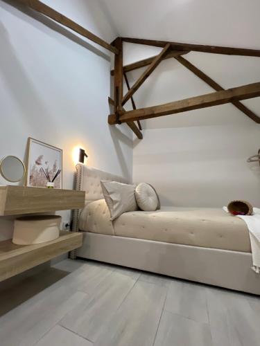 a white living room with a couch and wooden beams at Suites Chic Cozy in Herencia