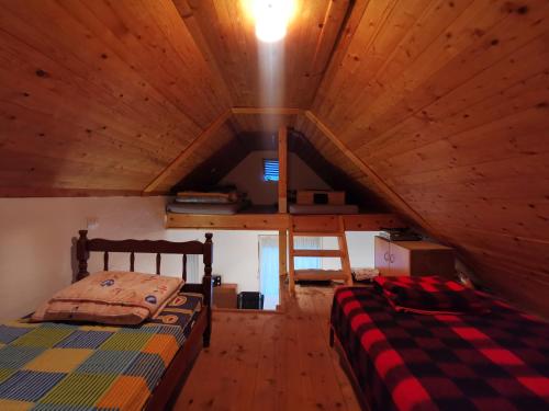1 Schlafzimmer mit 2 Betten in einem hölzernen Dachgeschoss in der Unterkunft Vikendica Olivia 