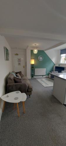 uma sala de estar com um sofá e uma mesa em Gilpin Suite em Cannock