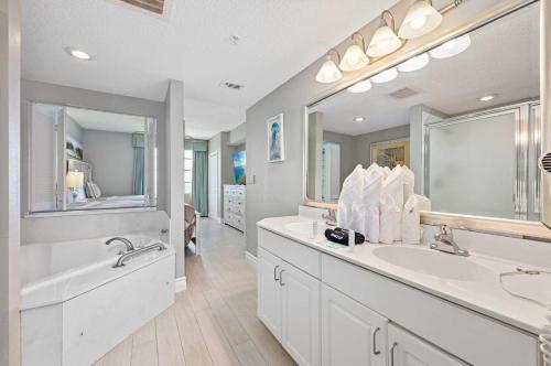 a bathroom with two sinks and a large mirror at Luxury 20th Floor 2 BR Condo Direct Oceanfront Resort Daytona Beach | 2027 in Daytona Beach