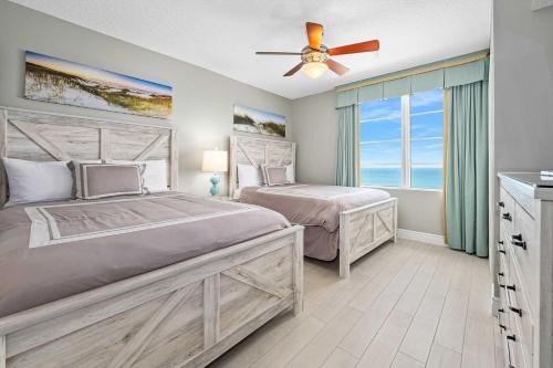 een slaapkamer met 2 bedden en een plafondventilator bij Luxury 20th Floor 2 BR Condo Direct Oceanfront Wyndham Ocean Walk Resort Daytona Beach | 2027 in Daytona Beach