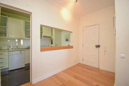 una cucina vuota con armadi bianchi e una porta di Cozy apartment near the beach a Estoril