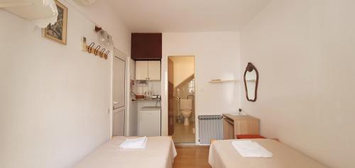 Habitación pequeña con 2 camas y cocina en Apartments Jurić - 2 A lovely room for 2 en Hvar