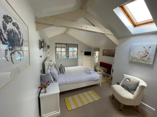a bedroom with a bed and a chair at Quay Cottage: Right on the Quay: Dittisham: Dartmouth: Devon at its best in Dittisham