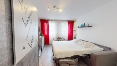 - une chambre avec un lit doté de rideaux rouges et d'un miroir dans l'établissement Studio Schilick, à Schiltigheim