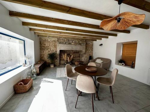 un salon avec une table et une cheminée dans l'établissement Maison chez Emilie, à Trégunc