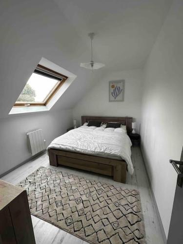 une chambre blanche avec un lit et une fenêtre dans l'établissement Maison chez Emilie, à Trégunc