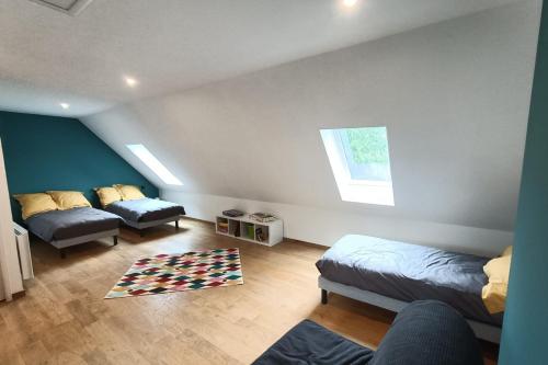 a attic bedroom with two beds and a rug at Gîte pour 9 personnes avec jardin à proximité du Puy Mary in Le Claux