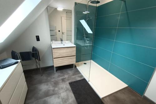 a bathroom with a sink and a glass shower at Gîte pour 9 personnes avec jardin à proximité du Puy Mary in Le Claux