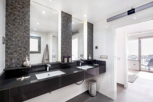 La salle de bains est pourvue de 2 lavabos et d'un grand miroir. dans l'établissement Puerto Banus Front Line 2 bedroom apartment, à Marbella