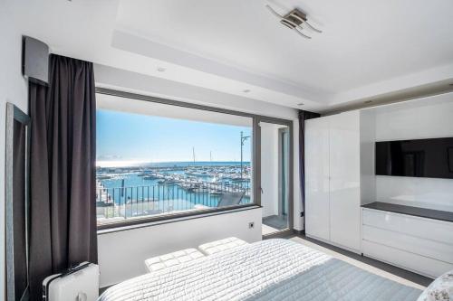 - une chambre avec une grande fenêtre offrant une vue sur le port dans l'établissement Puerto Banus Front Line 2 bedroom apartment, à Marbella