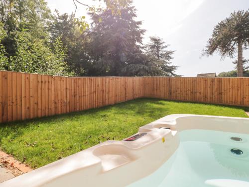 a bath tub sitting in a yard next to a fence at The Nest in Bridgwater