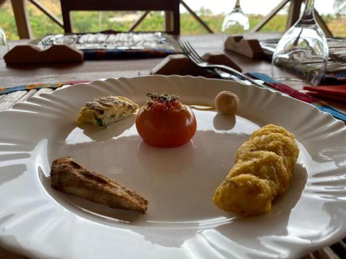 a white plate with food on a table at Monte Mar SãoTomé in M. Peixe