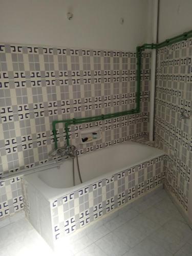a bathroom with white tiles on the wall and a shelf at COMFORT RENT in Lamía
