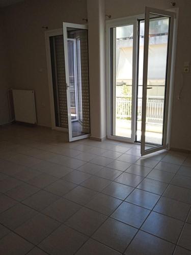 an empty room with doors and a tiled floor at COMFORT RENT in Lamía