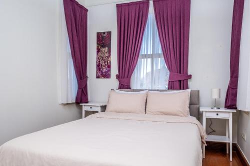 a bedroom with a large bed with purple curtains at Pavilion with Bosphorus View in Anadolu Hisari in Istanbul