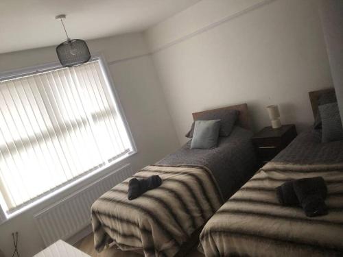 a bedroom with two beds and a window at 15 Comfort House 2 bed townhouse with parking in Scunthorpe