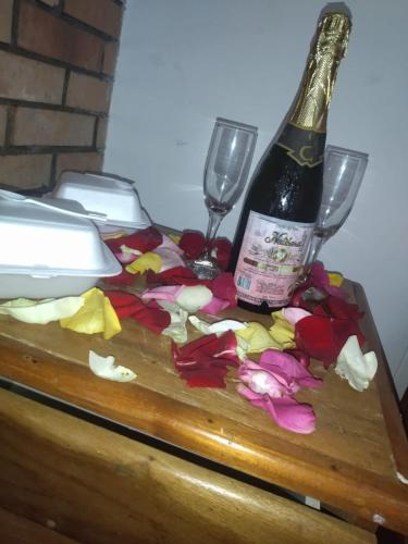 Una botella de vino y dos copas en una mesa en Hotel Torreon De Rionegro, en Rionegro
