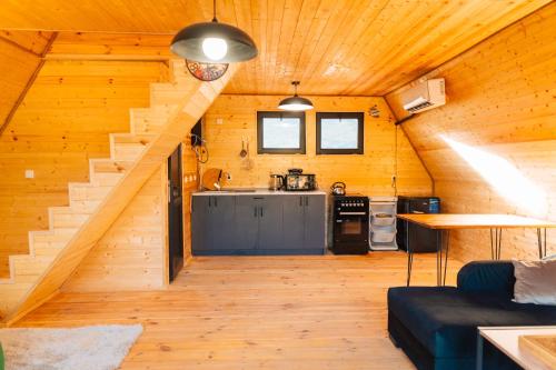a kitchen and living room in a log cabin at Oda Riverside Cottages in Aragvispiri
