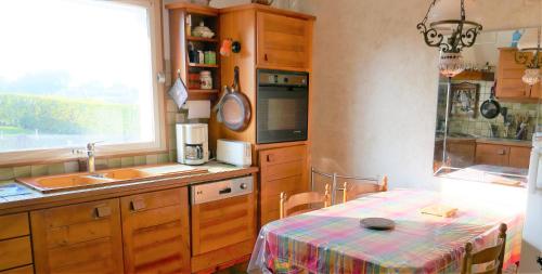 une cuisine avec une table, un évier et une fenêtre dans l'établissement Belle demeure Perros Plage à Pieds - Ty Dour Glaz, à Perros-Guirec