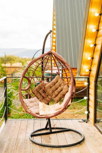 a wicker chair on a porch at Oda Riverside Cottages in Aragvispiri