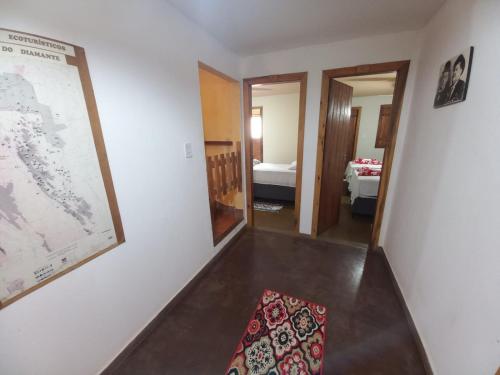 un couloir avec une chambre avec une carte sur le mur dans l'établissement Capim Rosa Chá, à Mucugê